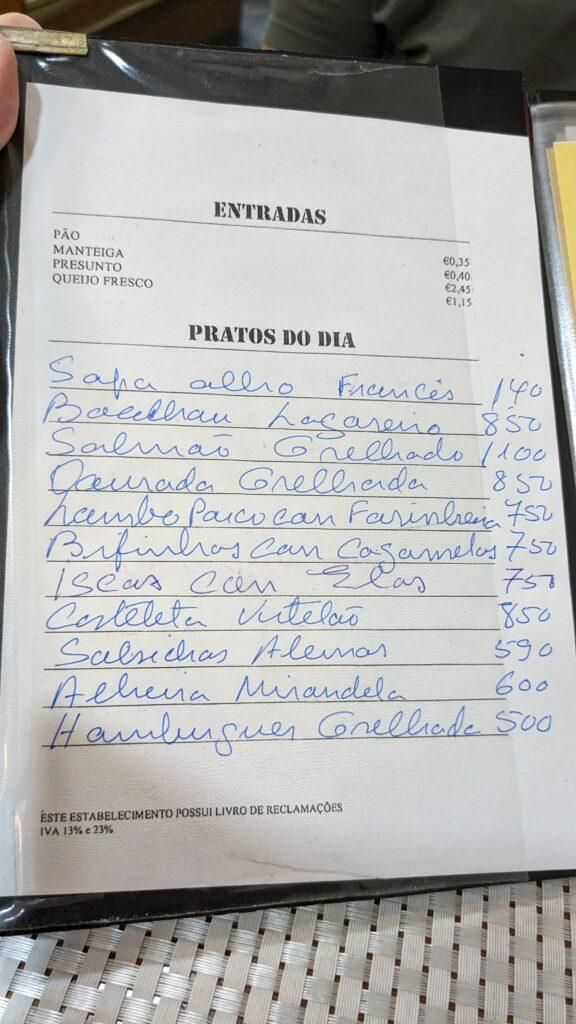 Ravintolan käsinkirjoitettu lounasruokalista, kokonaan portugaliksi. Kallein annos 8,50€